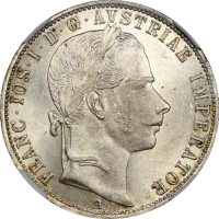 Αυστρία 1861 A – Silver 1 Florin – NGC MS63 Αυθεντικό ασημένιο νόμισμα 1 Florin του 1861, κοπής Βιέννης (νομισματοκοπείο «A»), από την περίοδο της βασιλείας του Αυτοκράτορα Φραγκίσκου Ιωσήφ Α΄ (Franz Joseph I) της Αυστριακής Αυτοκρατορίας. Το νόμισμα απεικονίζει στην εμπρόσθια όψη το πορτρέτο του Αυτοκράτορα Φραγκίσκου Ιωσήφ Α΄, ενώ στην οπίσθια όψη δεσπόζει ο εντυπωσιακός αυτοκρατορικός δικέφαλος αετός με τα εραλδικά σύμβολα της δυναστείας των Αψβούργων. Πιστοποιημένο από την NGC με βαθμό MS63 (Mint State 63), διατηρείται σε εξαιρετική ακυκλοφόρητη κατάσταση, με όμορφη λεπτομέρεια και συλλεκτική εμφάνιση. Χαρακτηριστικά: Χώρα: Αυστρία (Austrian Empire) Έτος: 1861 Ονομαστική αξία: 1 Florin (Gulden) Νομισματοκοπείο: A – Βιέννη Μέταλλο: Ασήμι 0,900 Βάρος: 12,35 γραμμάρια Διάμετρος: 29 χιλιοστά Πιστοποίηση: NGC MS63 Περίοδος: Franz Joseph I (1848–1916) Ένα ιδιαίτερα ελκυστικό ιστορικό ασημένιο νόμισμα του 19ου αιώνα, ιδανικό για συλλέκτες αυστριακών νομισμάτων, ασημένιων Florin και πιστοποιημένων νομισμάτων υψηλής διατήρησης. Μια αξιόλογη προσθήκη σε κάθε προσεγμένη νομισματική συλλογή.